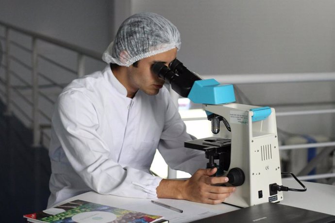 Un investigador usando un microscopio.