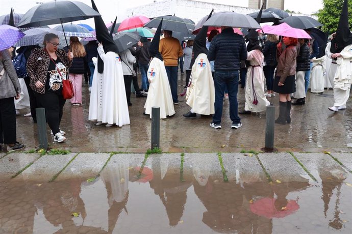 Nazarenos de la Hermandad del Cautivo de San Pablo salen de la Iglesia tras suspenderse por la lluvia su estación de penitencia