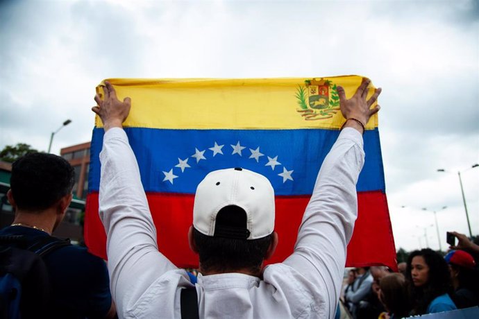 Archivo - Manifestante opositor con una bandera de Venezuela durante una protesta contra el Gobierno de Nicolás Maduro