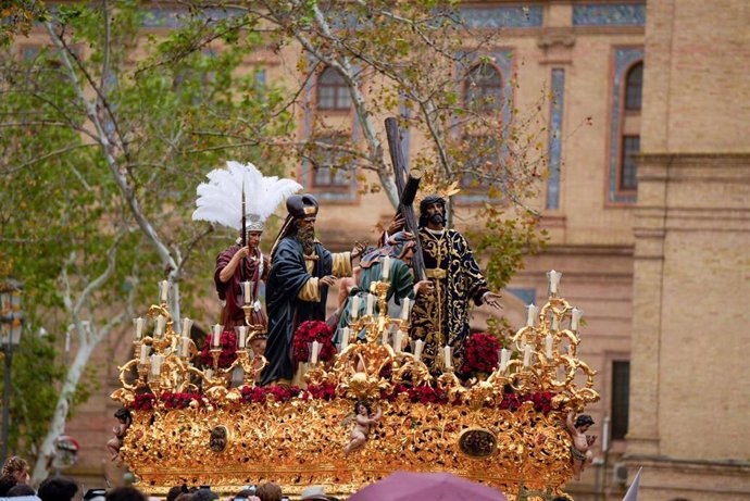 Salida del paso del Cristo de la Victoria de la hermandad de la Paz, donde se ven paraguas por las precipitaciones en la Iglesia de San Sebastián durante la salida de la cofradía a 24 de marzo del 2024 en Sevilla, (Andalucía España). La Semana Santa es 