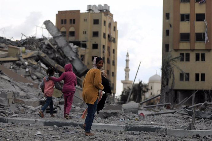 GAZA, March 25, 2024  -- People walk past destroyed buildings in the central Gaza Strip, on March 25, 2024. The Palestinian death toll in the Gaza Strip from ongoing Israeli attacks has risen to 32,333, the Hamas-run Health Ministry said in a press statem