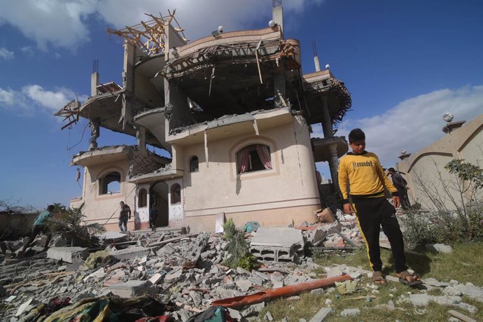 Palestinos frente a un edificio destruido por un bombardeo del Ejército de Israel contra la ciudad de Rafá, en el sur de la Franja de Gaza (archivo)