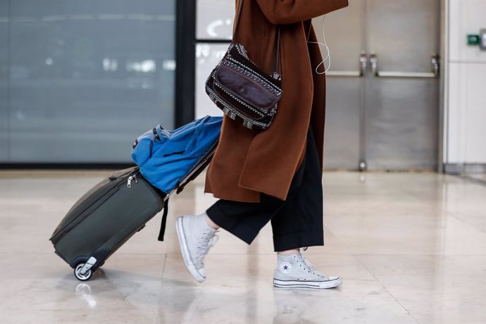 Archivo - Un viajera, camina con su maleta por los pasillo del aeropuerto Adolfo Suárez Madrid-Barajas.
