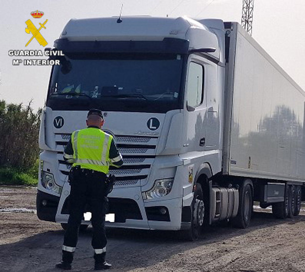 Un guardia civil observa el camión recuperado.