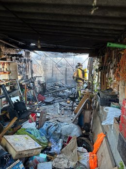 Un bombero del CEIS durante las labores de extinción del incendio originado en un cobertizo junto a una vivienda en Ceutí (Murcia)