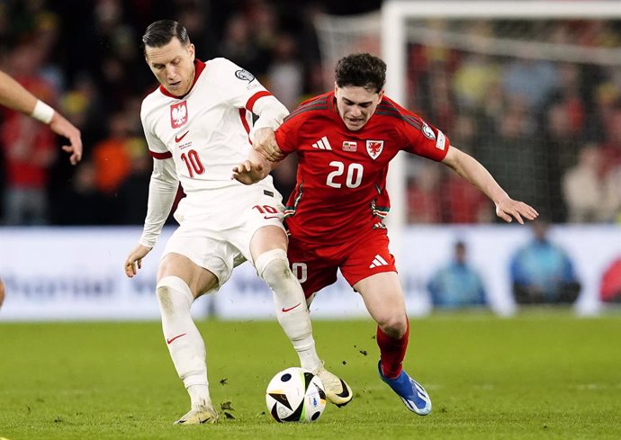 26 March 2024, United Kingdom, Cardiff: Wales' Daniel James and Poland's Piotr Zielinski (L) battle for the ball during the UEFA Euro 2024 Qualifying play-off final soccer match between Wales and Poland at the Cardiff City Stadium. Photo: Nick Potts/PA Wi