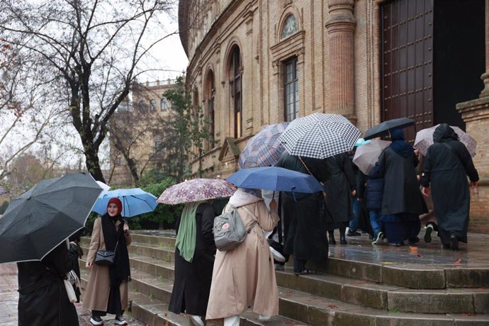 Archivo - Varias personas se protegen de la lluvia con sus paraguas en Sevilla (Andalucía, España). 