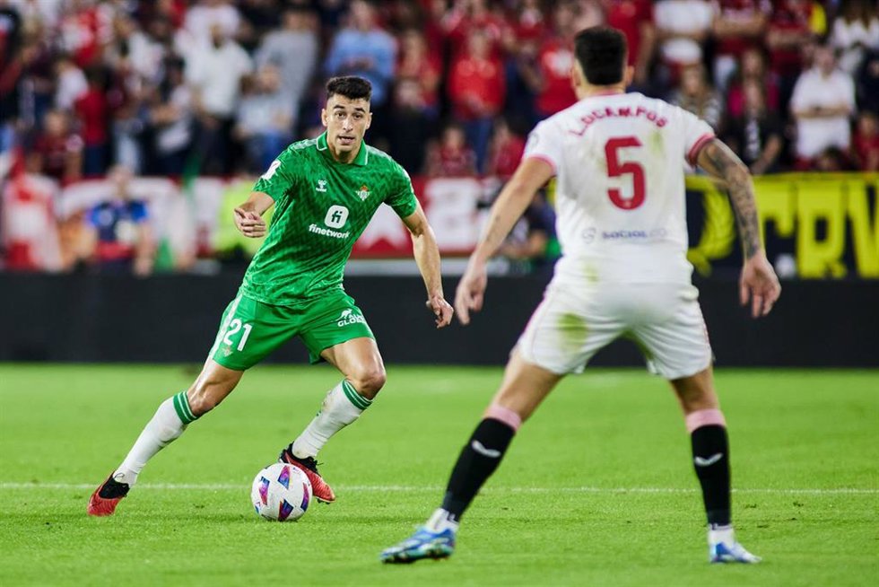 Archivo - El mediocentro del Real Betis Marc Roca, ante el sevillista Lucas Ocampos, en el Sevilla-Betis de LaLiga EA Sports 2023-2024, disputado en el Ramón Sánchez-Pizjuán.