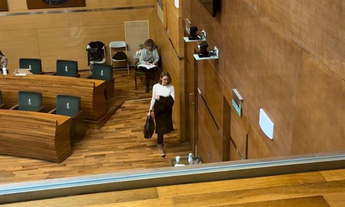 Imagen de los asientos de Vox en el pleno del Ayuntamiento de València vacíos tras abandonar sus ediles la sesión y de una de las representantes de este partido saliendo de la sala.