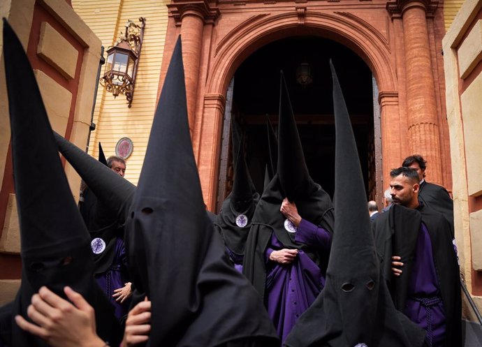 Hermanos de la Hermandad de San Bernardo se marchan de la parroquia tras suspenderse por la lluvia su estación de penitencia, a 27 de marzo de 2024, en Sevilla, Andalucía (España).