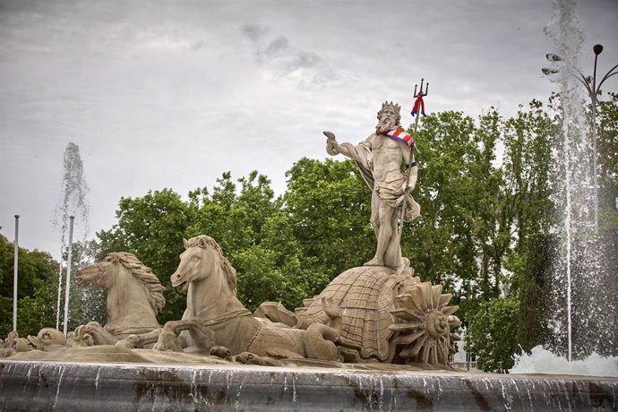 Archivo - La estatua de la fuente de Neptuno, con una bufanda del Atlético de Madrid