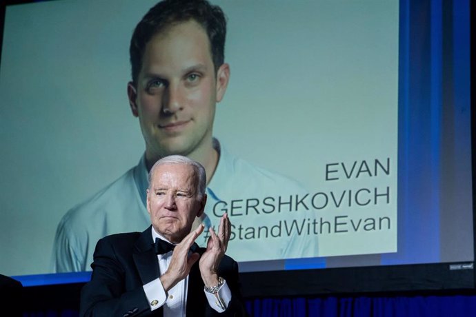Archivo - Joe Biden, frente a una imagen del periodista detenido Evan Gershkovich 
