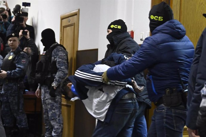 Agentes del Servicio Federal de Seguridad de Rusia con uno de los sospechosos del atentado de Moscú.