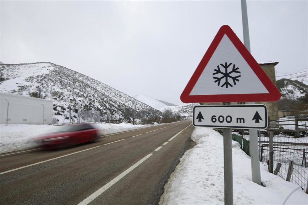 Vehículo circulando por una carretera rodeada por nieve, en una imagen de archivo.