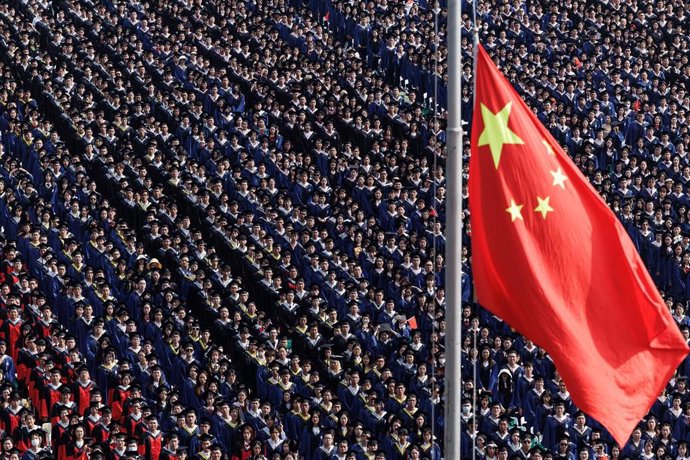 Archivo - 20 June 2023, China, Wuhan: Students from Wuhan University watch the flag raising ceremony during the graduation ceremony in the school's stadium in Wuhan. Photo: Ren Yong/SOPA Images via ZUMA Press Wire/dpa