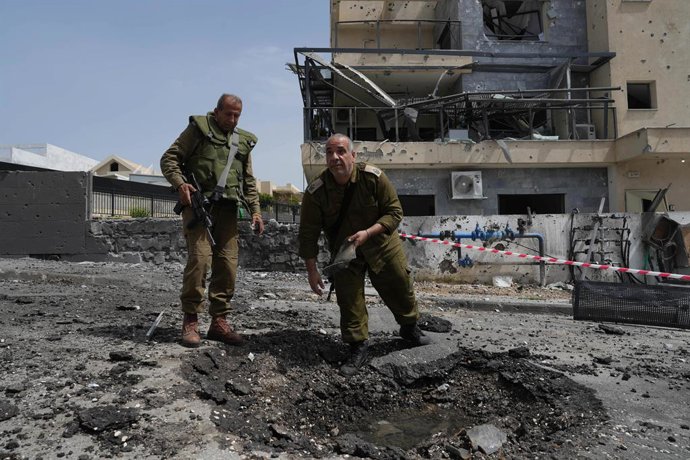 KIRYAT SHMONA, March 27, 2024  -- Israeli security forces look at the damage after a rocket fired by Lebanon's Hezbollah in the city of Kiryat Shmona in northern Israel, March 27, 2024. A man was killed as a rocket attack launched Wednesday by Hezbollah m