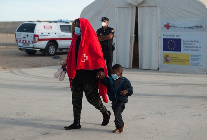 Archivo - September 11, 2020, Malaga, Spain: A subsaharan migrant wearing a face mask as a precaution seen walking with her child after being rescued by a Spanish coast guard boat on the Mediterranean Sea..An intensive patrol of the border by Moroccan's