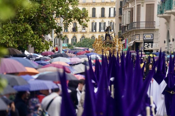 Nazarenos de la hermandad procesionan por las calles de Málaga  acompañando al Cristo El RIco, a 27 de marzo de 2024, en Málaga, Andalucía (España). 