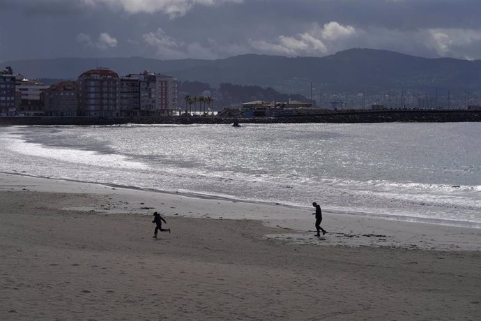 Archivo - Varias personas pasean por la playa de Silgar en Sanxenxo.