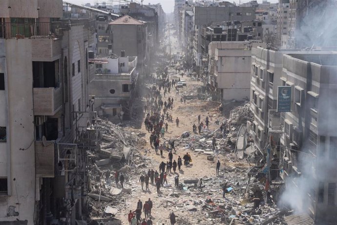 Ciudadanos palestinos en una calle destruida por los bombardeos israelíes en la Franja de Gaza