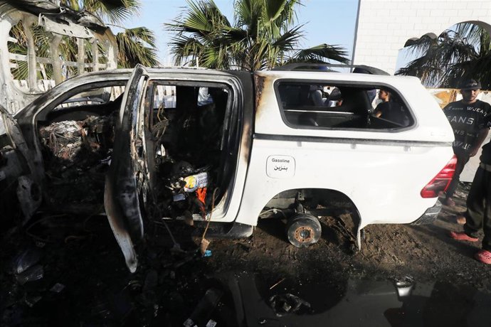 April 2, 2024, Dair El-Balah, Gaza Strip, Palestinian Territory: Palestinians inspect the heavily damaged vehicles after the Israeli attacks target officials working at the US-based international volunteer aid organization World Central Kitchen (WCK), i