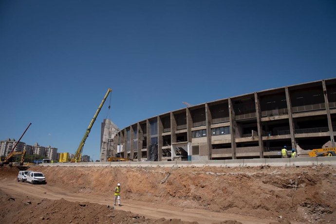 Archivo - Un operario camina frente a las obras de remodelación del Spotify Camp Nou.