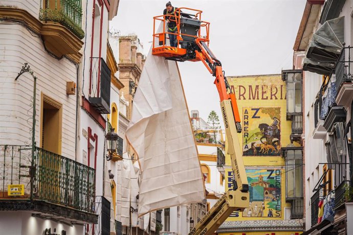 Trabajador instalando los toldos en la calle Sierpes de Sevilla.