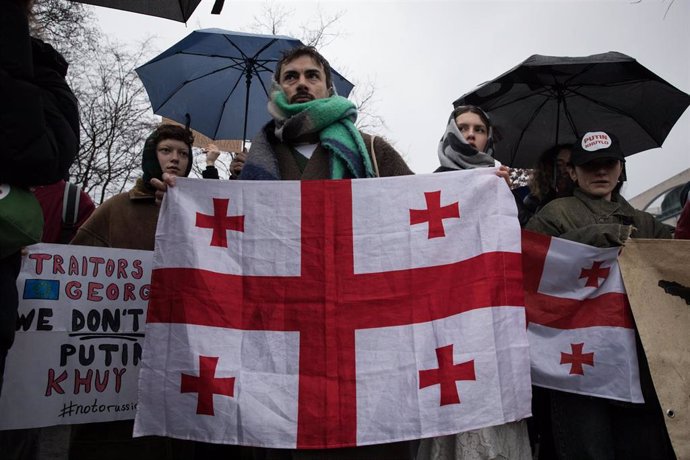 Archivo - Un manifestante en Georgia con la bandera nacional