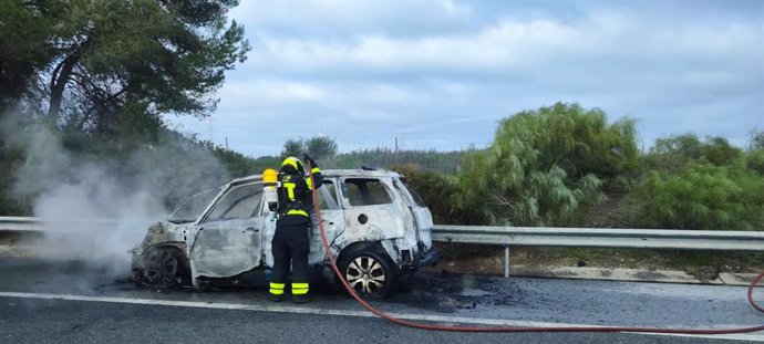 Un efectivo del Consorcio de Bomberos de Cádiz en la extinción del vehículo incendiado en la AP-4.