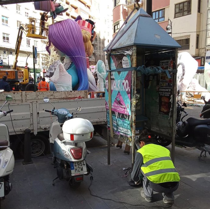 Imatge dels treballs per a retirar una de les cabines de telfon que quedaven als carrers de la ciutat de Valncia, de les quals s'han eliminat tots aquests elements.