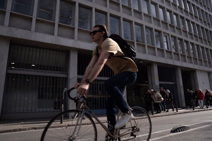 Archivo - Una persona circula con una bicicleta por delante de la fachada de la Conselleria de Agricultura de la Generalitat, a 28 de febrero de 2024, en Barcelona, Catalunya (España).