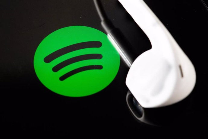 Archivo - FILED - 07 February 2022, Berlin: Headphones are on the screen of a smartphone, which displays the logo from the music streaming service Spotify. Spotify released figures on Tuesday on how artists generate money on its music streaming service. P