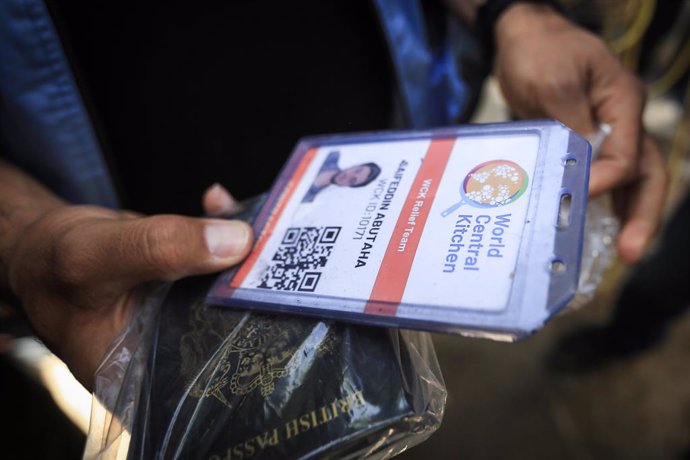 03 April 2024, Palestinian Territories, Rafah: A person carries the credentials of one of the members of the World Central Kitchen aid group, who were killed in an Israeli air strike, outside the morgue of Abu Youssef Al-Najjar Hospital in Rafah in the so