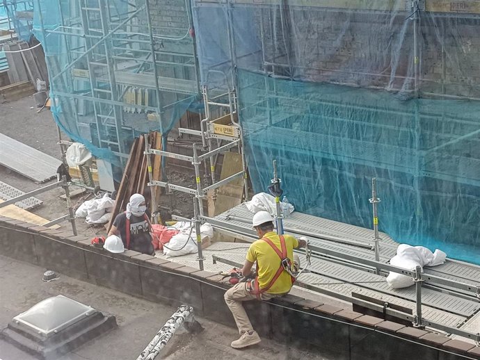 Archivo - Dos trabajadores trabajan en las obras de un edificio en Bilbao