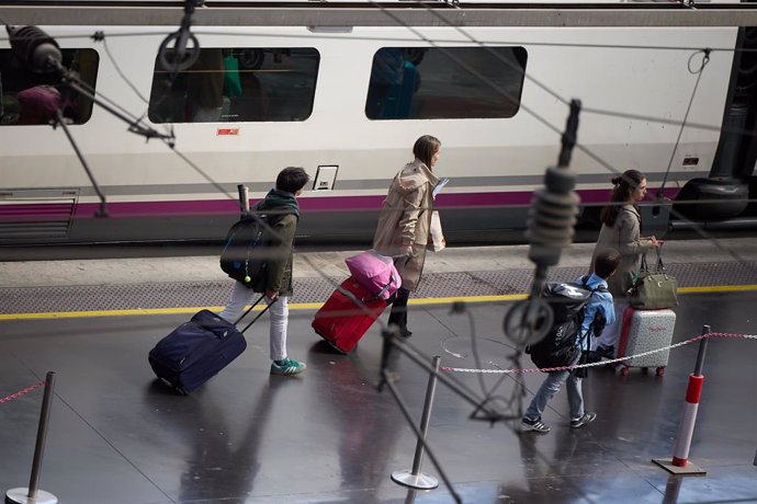 Varias personas esperan a un tren en un andén con motivo de la segunda fase de la operación Salida por Semana Santa en la Estación de Atocha, a 27 de marzo de 2024, en Madrid
