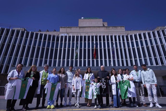 Foto de familia tras la entrega de las 'batas más fuertes', confeccionadas con camisetas del Real Betis, para menores hospitalizados, a las puertas del Hospital de Valme.