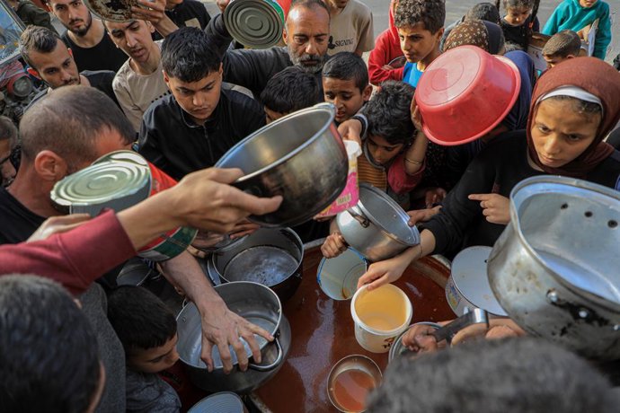 GAZA, March 31, 2024  -- People wait to receive food relief in the southern Gaza Strip city of Rafah, on March 30, 2024. The United Nations Office for the Coordination of Humanitarian Affairs (OCHA) said on Thursday that more than 1.1 million people in 