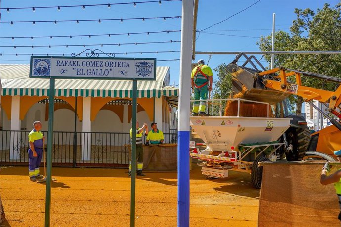 Archivo - Una cuadrilla de trabajadores cubriendo las calles de albero del recinto ferial
