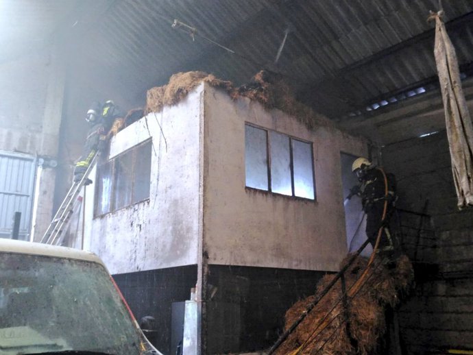 Bomberos extinguen un incendio de hierba en una nave de Beranga.