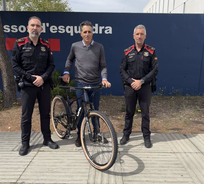 Els agents dels Mossos i Miguel Induráin amb la bici recuperada
