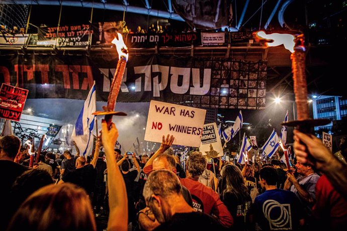 March 30, 2024, Tel Aviv, Israel: Hostage family supporters hold torches and a placard during a protest  in Tel Aviv Saturday, March 30 2024. On Saturday, tens of thousands took to the across Israel in the largest protest since Oct 7 against the current g