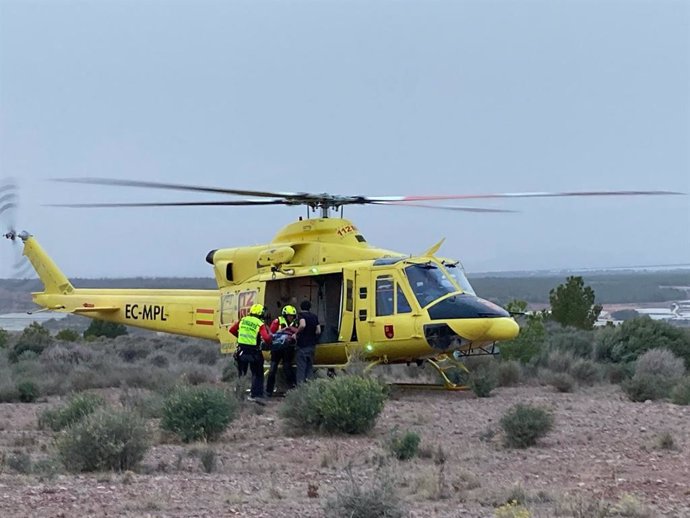 Personal sanitario introduce al herido en un helicóptero