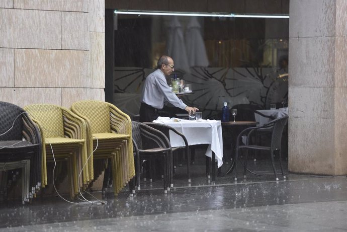 Archivo - Un camarero recoge una mesa en una terraza 