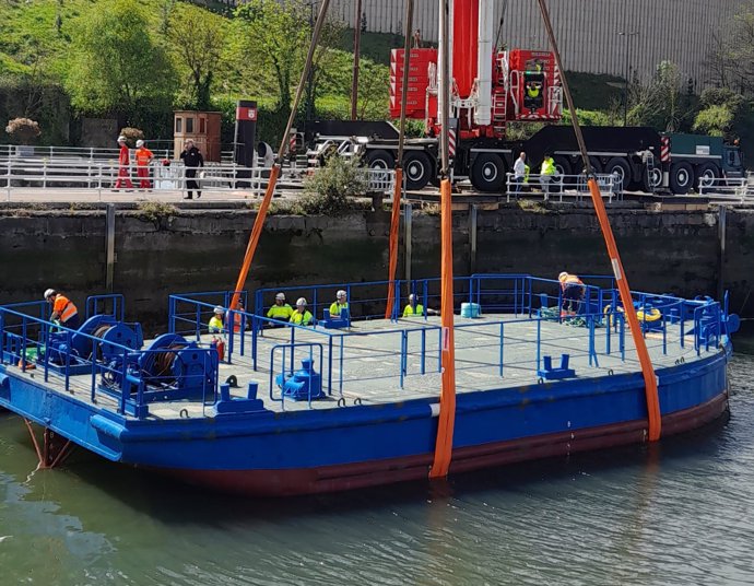 Maniobra para trasladar la gabarra del dique del Museo Marítimo de Bilbao a la ría.