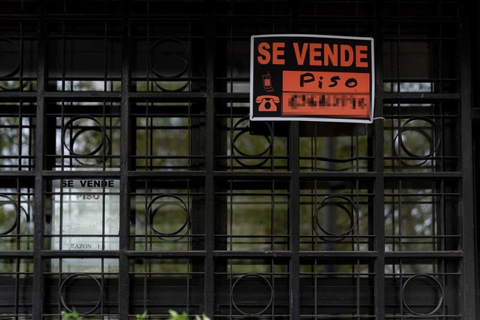 Vista de un cartel de 'Se vende' en un portal de un edificio