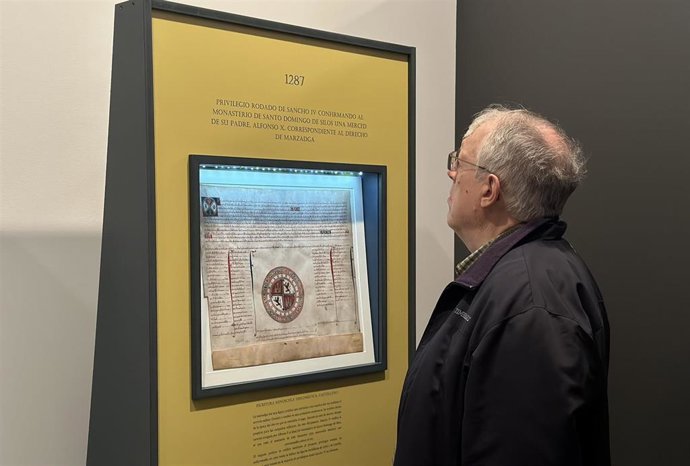 Un hombre observa uno de los documentos expuestos en la exposición 'El documento medieval en la cancillería de Alfonso X'.