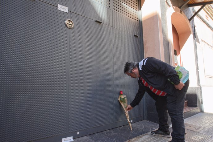 Un hombre deposita una rosa en el garaje de la vivienda donde un hombre ha matado presuntamente a su mujer y sus dos hijos menores, 10 de abril de 2024, en El Prat de Llobregat, Barcelona, Catalunya (España).