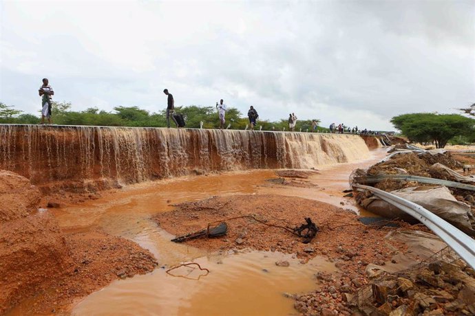 Archivo - Varias personas caminan junto a una carretera destruida por las lluvias torrenciales en el norte de Kenia en noviembre de 2023 (archivo)