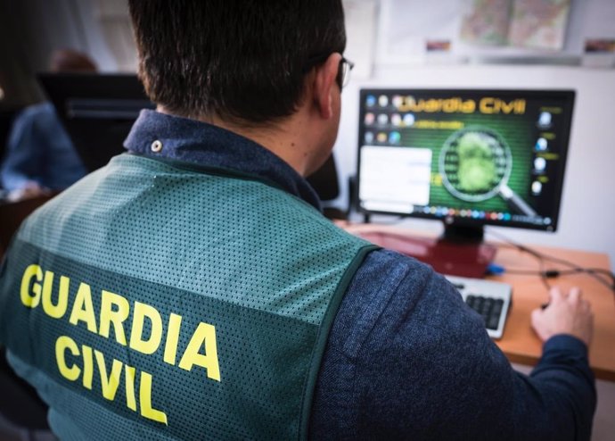 Archivo - Un agente de la Guardia Civil maneja un ordenador