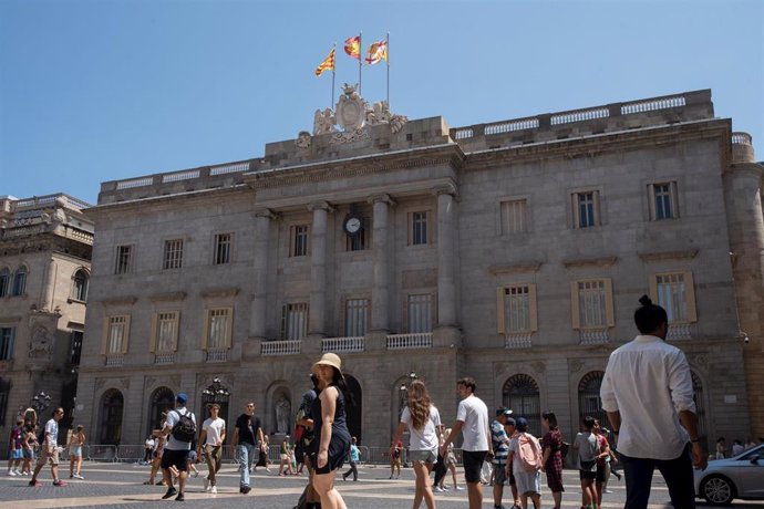 Archivo - Varias personas caminan delante del edificio del Ayuntamiento de Barcelona, a 1 de agosto de 2023, en Barcelona, Catalunya (España)